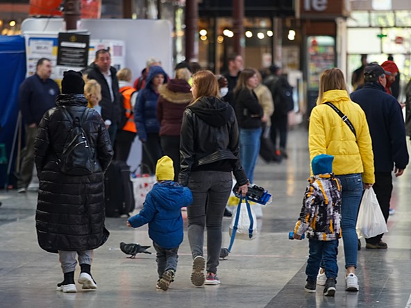 ukrainian refugees, including two children, walk through train station